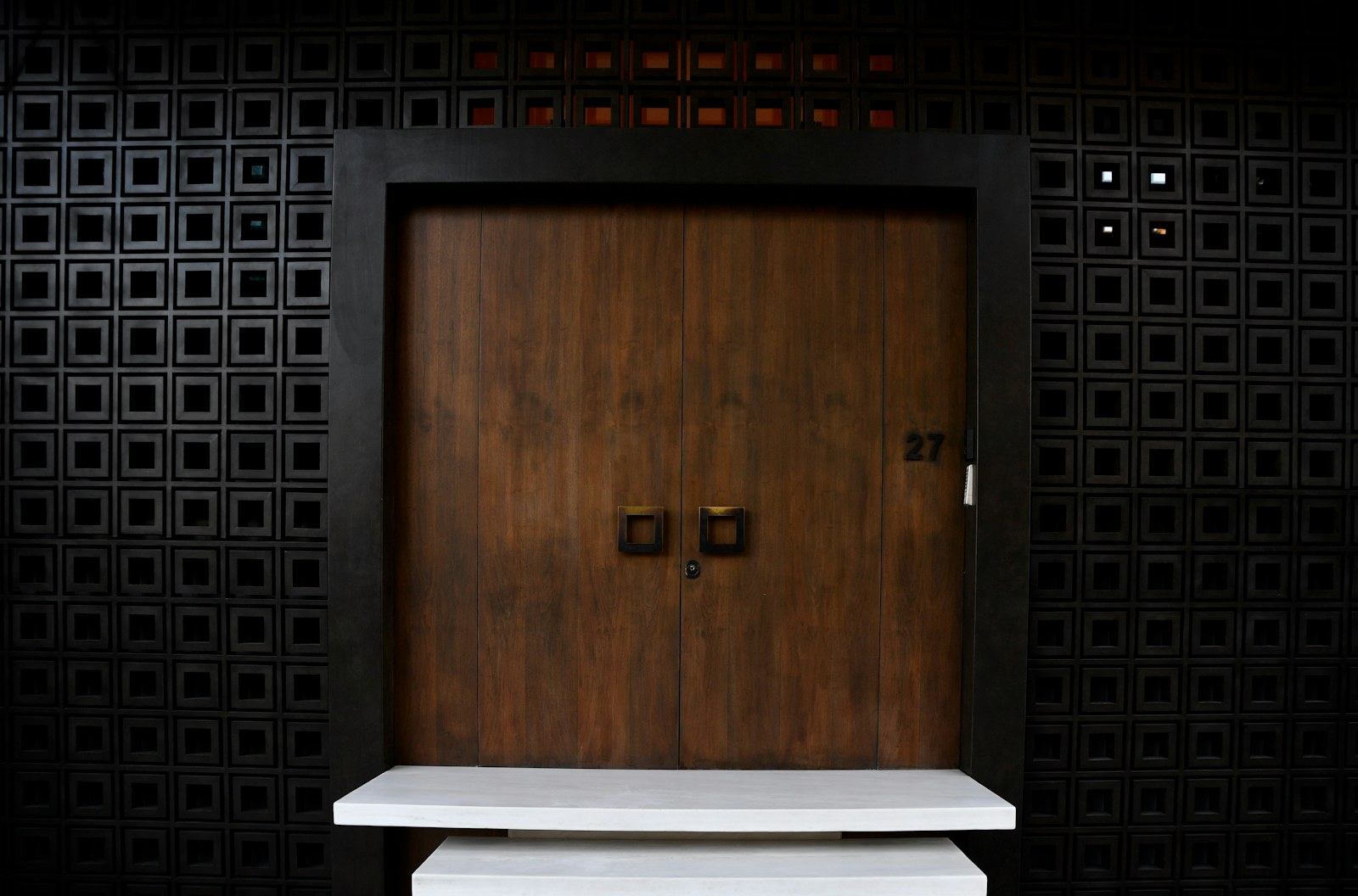 Timber entrance with carefully aligned square handles